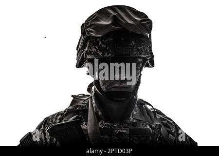 Shoulder portrait of modern army infantry soldier with dirty face in digital camouflage battle uniform, combat helmet, tactical sunglasses looking at Stock Photo