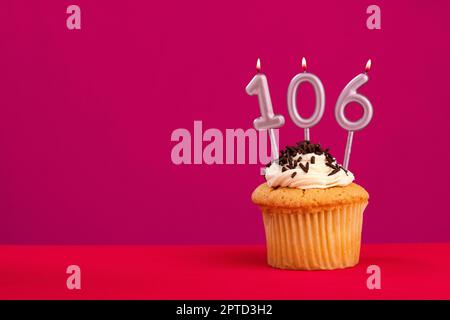 Candle number 106 - Cake birthday in rhodamine red background Stock Photo