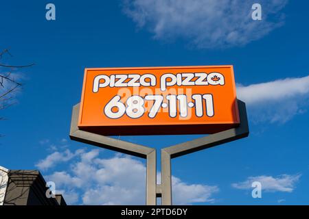 Close up of Pizza Pizza pole sign with blue sky in background Stock Photo