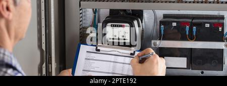 Electricity Counter Metering System. Engineer Reading Meter Stock Photo
