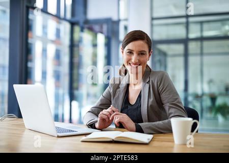 Remember that every challenge is just the potential for growth. Portrait of a young woman working on a laptop in an office Stock Photo