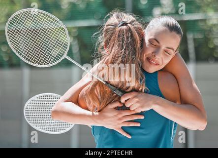 Badminton, success and friends hug after a sports match or training game for support, love and congratulations. Fitness, smile and happy women hugging Stock Photo
