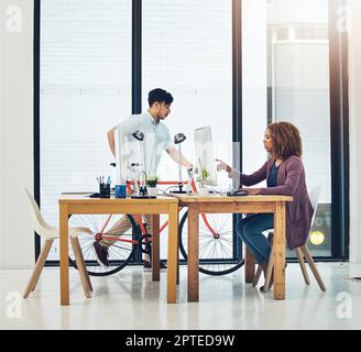 Keeping things green in the office. two creative colleagues working together in their office. Stock Photo