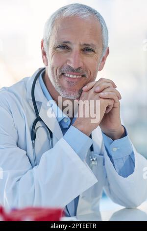 Healthcare is my passion. Portrait of a mature doctor sitting in a hospital Stock Photo