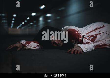 The girl was hit by a car and lying died on the road. full of blood left unattended, Horror bloodthirsty woman ghost horror she death and scary at nig Stock Photo