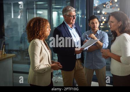 Getting it done, whatever it takes. a team of dedicated colleagues working together in their office after hours. Stock Photo