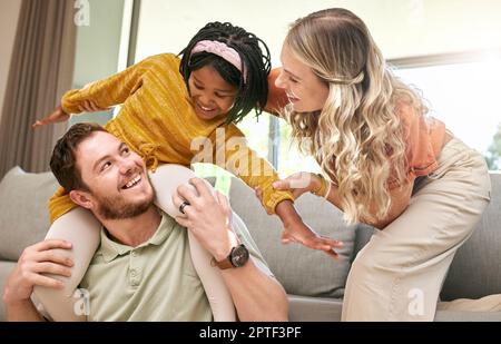 Bonding, diversity and child with parents in foster care for love, happy and safety in a family home. Playful, smile and father, mother and African gi Stock Photo