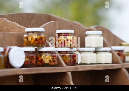 Nuts and honey in small jars on shelf Stock Photo