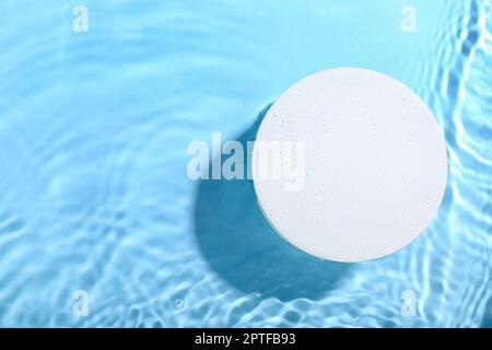 Decorative plaster podium in water on blue background Stock Photo