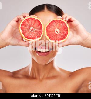 Grapefruit, skincare and wellness of a woman holding fruit, skincare and vitamin c for face glow. Model with fruits for health, cosmetic eye treatment Stock Photo