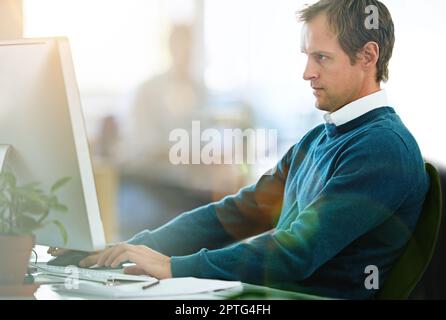 Hes brings his A game to work everyday. a designer working at his computer in an office Stock Photo