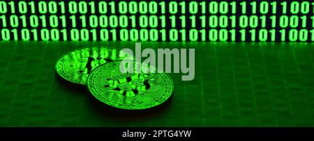 A pair of bitcoins lies on a cardboard surface on the background of a monitor depicting a binary code of bright green zeros and one units on a black b Stock Photo