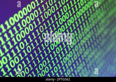 Macro shot of binary code on the monitor of an office computer. The concept of the programmer's work. The flow of digital information strings Stock Photo