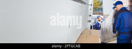 Happy Movers Unloading Furniture From Truck. Mover Service Stock Photo