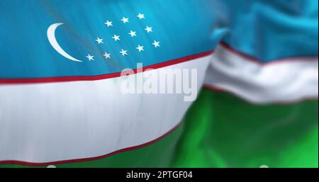 Close up view of the Uzbekistan national flag waving in the wind. The Republic of Uzbekistan is a country located in Central Asia. Fabric textured bac Stock Photo