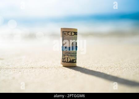 Rolled Up Bundle Of Fifty Dollar Banknotes At Beach Stock Photo