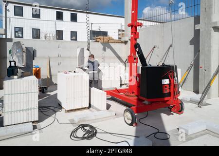 bricklayer erects a concrete wall on a construction site Stock Photo