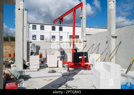 bricklayer erects a concrete wall on a construction site Stock Photo