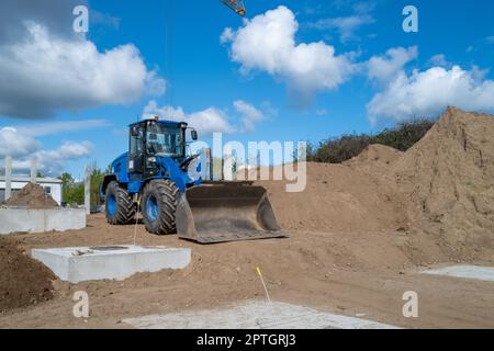 a big blue wheel loader stands on a construction site Stock Photo
