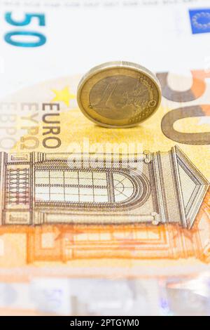 One Euro coin on the 50 Euro note banknote. Business and money concept. Stock Photo