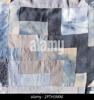 detail of hand-crafted patchwork quilt from pieces of various silk fabrics sewn in convergence technique Stock Photo