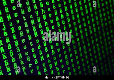 Macro shot of a glitch on the monitor of an office computer. The concept of introducing a virus into a personal data keeper. Stream of random green sy Stock Photo