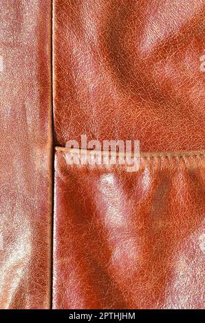 Brown leather texture. Useful as background for any design work. Macro photography of outerwear made of genuine leather Stock Photo