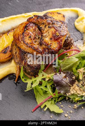 Succulent thick juicy portions of grilled fillet steak served with greens Stock Photo