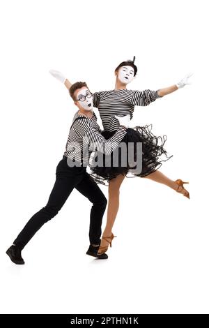 Full-length portrait of mimes in striped shirts. Man and woman dressed as actors of pantomime theater isolated on white background Stock Photo
