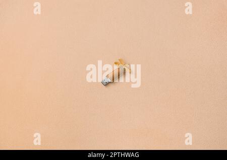 Orange usb flash memory card with a bow lies on a blanket of soft and furry light orange fleece fabric. Classic female gift design for a memory card Stock Photo