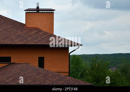 The house is equipped with high-quality roofing of shingles (bitumen tiles). A good example of perfect roofing. The roof is reliably protected from ad Stock Photo