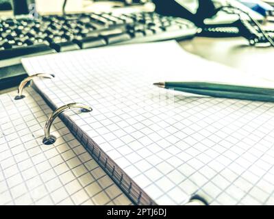 a sheet of white paper in a cage from a notebook. diary to record all personal affairs and tasks. lined sheet of paper. retro notepad, note taking on Stock Photo