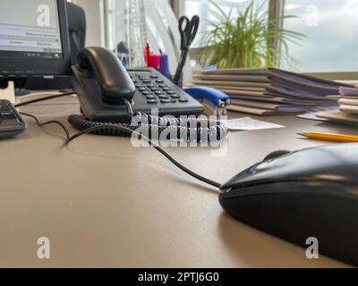 Black modern computer mouse keyboard and telephone on a working office table in a business company. Stock Photo