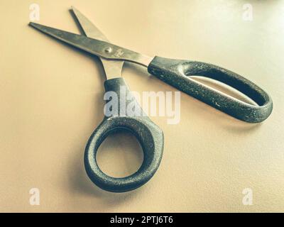 stationery on the table in the office. metal scissors with black handles. paper cutting, tool for work. scissors on a white matte background. Stock Photo