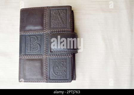 A brown, old, leather-covered notebook on a beige background. Stock Photo