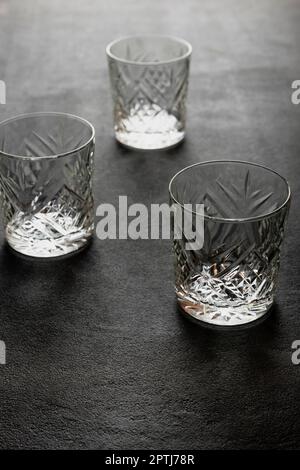 Empty glasses of old fashion for whiskey or rum on a black concrete background, close-up, the concept of booze and cocktails in a bar Stock Photo