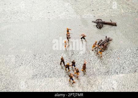 Small action figures of toy soldiers of people with guns and weapons. Stock Photo