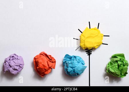 Creative thinking ideas and innovation concept. Paper scrap ball yellow colour with light bulb symbol Stock Photo