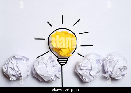 Creative thinking ideas and innovation concept. Paper scrap ball yellow colour with light bulb symbol Stock Photo
