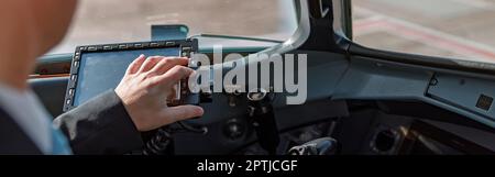 Aircraft pilot sitting in cockpit and using flight display Stock Photo
