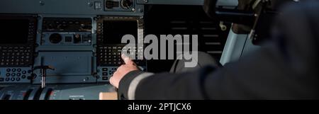 Airline pilot using instrument panel in aircraft cockpit Stock Photo