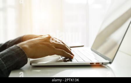 Close up of man hands using laptop at home office. Concept of searching web, browsing information. soft focus Stock Photo