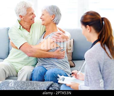 Its going to be okay now. A doctor explaining positive test results to an overjoyed senior patient and her husband Stock Photo