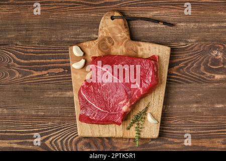 Top view of raw top side beef steak on wooden tabletop Stock Photo