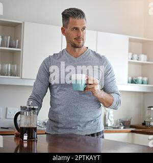Im happiest with a coffee in hand. a man drinking coffee in the morning at home. Stock Photo
