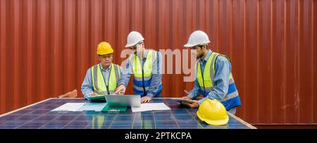 Project manager pointing at  shipping schedule on laptop computer, explain to contractor  about planning for next shipment. They use solar cell panel Stock Photo