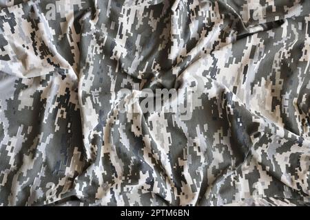 Fabric with texture of Ukrainian military pixeled camouflage. Cloth with camo pattern in grey, brown and green pixel shapes. Official uniform of Ukrai Stock Photo