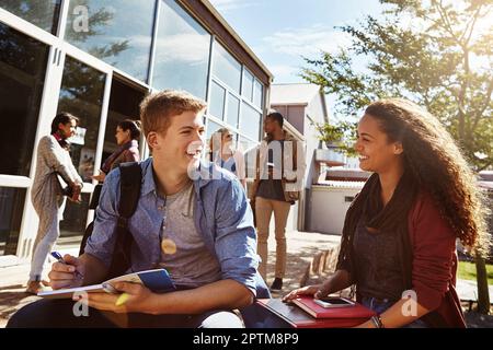 We should study together more often. two students studying together on campus. Stock Photo