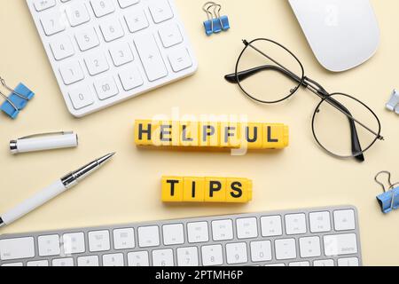 Flat lay composition with phrase Helpful Tips made of yellow cubes on beige background Stock Photo