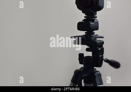 External photographic flash is mounted on the synchronizer, which stands on a tripod. lighting equipment objects. Set of professional studio photograp Stock Photo